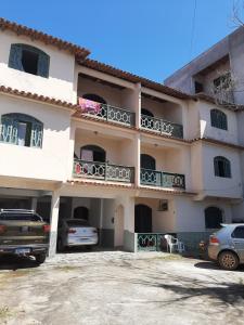 a large building with cars parked in a parking lot at Hospedagem Familiar in Piúma