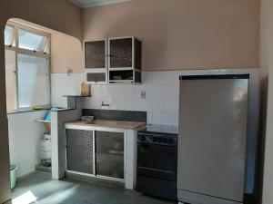 a kitchen with a stove and a refrigerator at Hospedagem Familiar in Piúma