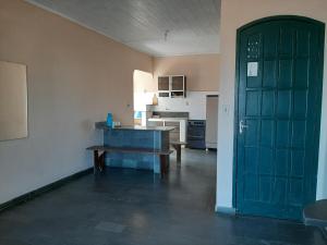 a kitchen with a door and a bench in a room at Hospedagem Familiar in Piúma +9 photos