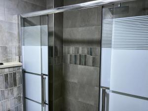 a shower with a glass door in a bathroom at Downtown Inn Madaba in Madaba