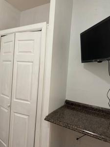 una camera con una porta e una televisione appesa a un muro di Classis King and Queen suites a Schenectady