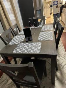 un tavolo in legno con 4 sedie e un computer portatile di Classis King and Queen suites a Schenectady