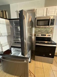 a kitchen with a stainless steel refrigerator and microwave at Classis King and Queen suites in Schenectady