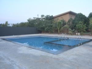 una piscina en medio de un patio en The Green Heritage Resort Igatpuri, en Balayaduri 4 fotos más