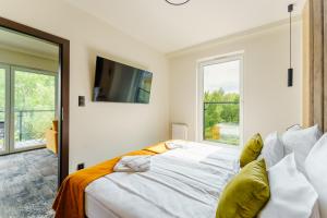 sypialnia z dużym łóżkiem i dużym oknem w obiekcie FACTORY RESORT wellness & spa w Kołobrzegu
