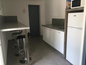 a kitchen with white cabinets and a white refrigerator at Sur les pas de Pagnol in Aubagne