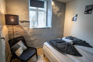 1 dormitorio con 1 cama, 1 silla y 1 ventana en City Center Getaway 3 by Berti en Stavanger
