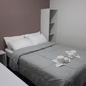 uma cama com duas tigelas e toalhas em Pousada Caribe Milagrense em São Miguel dos Milagres
