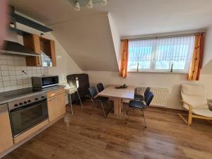 - une cuisine et une salle à manger avec une table et des chaises dans l'établissement Ferienwohnung Schupfer, à Aigen im Ennstal