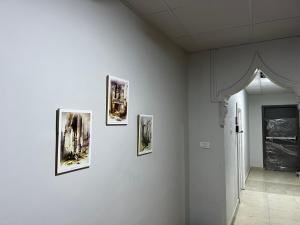 four pictures on a white wall in a room at Downtown Inn Madaba in Madaba