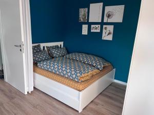 ein Schlafzimmer mit einem Bett mit einer blauen Wand in der Unterkunft FEWO "Rabennest " Gemütliche Wohnung nahe Rabensteinklinikum - kein separates Schlafzimmer, Studiowohnung in Chemnitz