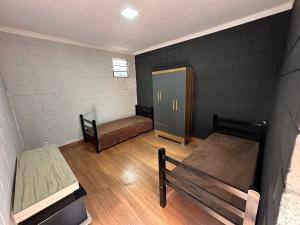 ジャカレイーにあるReserva Athenas - Clube de campoのベッド2台とロッカーが備わる小さな客室です。