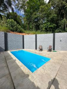 una piscina con due sedie accanto a una recinzione di Reserva Athenas - Clube de campo a Jacareí