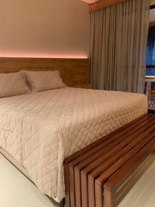 a bedroom with a large bed with a wooden headboard at Beira-Mar EcoResort Carneiros perto da Igrejinha in Tamandaré +24 photos