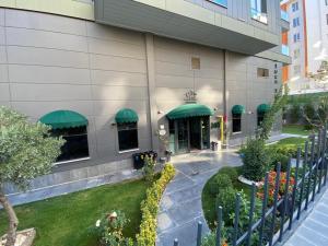 an exterior view of a building with green awnings at YOUR HOUSE Apart Otel in Karaköprü Köyü