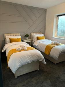 2 camas con toallas en un dormitorio en Cozy 3 Bed Home in Halifax with Secure Parking - Long & short stays welcome!, en Halifax