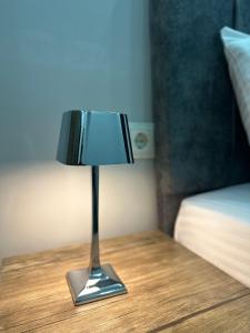 una pequeña lámpara sentada en una mesa junto a una cama en YOUR HOUSE Apart Otel en Karaköprü Köyü