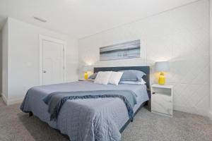 a white bedroom with a bed with a blue blanket at Mins to the Beach/King Beds/Arcade-Snowbird Deals! in Perdido Key