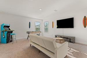 a living room with a couch and a flat screen tv at Mins to the Beach/King Beds/Arcade-Snowbird Deals! in Perdido Key