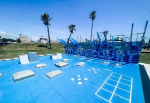 an empty playground with blue and white chairs on it at Moody Gardens Oasis (Unit 8) in Galveston