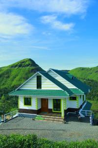a yellow house with a grassy hill behind it at The Kissing Mountains in Vagamon