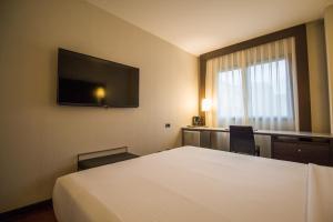 a hotel room with a bed and a flat screen tv at Hotel Vilamarí in Barcelona