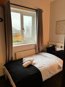 1 cama en un dormitorio con ventana en Cozy 3 Bed Home in Halifax with Secure Parking - Long & short stays welcome!, en Halifax