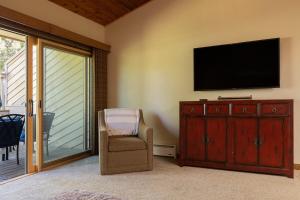 een woonkamer met een tv en een stoel bij Sun Valley Condo on the Green with Dollar Views in Sun Valley