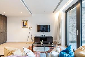a living room with a couch and a table at Chic and Sleek Oasis in London