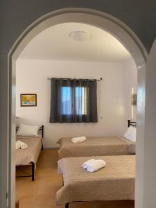 um quarto com três camas e uma janela em Ios Village View em Chora, Ios