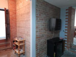 a room with a brick wall and a tv on a wall at Contemax in Cetraro