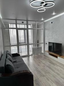 a living room with a couch and a flat screen tv at Аэропорт Алтын сити in Almaty