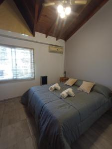 1 dormitorio con 1 cama grande y 2 toallas. en Escala Ezeiza - Departamento amplio con cochera en Luis Guillón