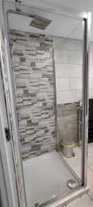 a shower with a glass door in a bathroom at A Whole Townhouse to you in Distington