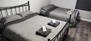 two beds in a bedroom with towels on them at A Whole Townhouse to you in Distington