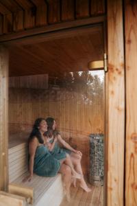 eine Gruppe von drei Frauen, die in einer Sauna sitzen in der Unterkunft Garczovka - domki, jacuzzi, sauna in Garcz