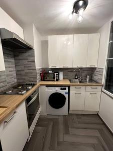 a kitchen with white cabinets and a stove top oven at Studio Suite in Pimlico/Victoria in London