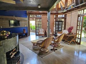 a living room with a fireplace and chairs and a tv at Chacara com Wi-Fi e piscina em Ouro Verde De Goias in Matão