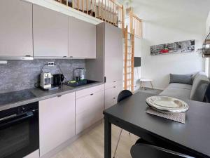 a kitchen with white cabinets and a table in a room at The Yellow House Nr 11 by Berti’s in Stavanger