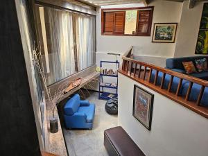 a living room with a staircase and a blue chair at Chacara com Wi-Fi e piscina em Ouro Verde De Goias in Matão