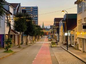 an empty street in a city with buildings at The Yellow House Nr 11 by Berti’s in Stavanger