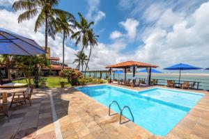 uma piscina com vista para o oceano em Pousada Villa do Sol em Genipabu