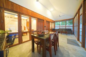 a dining room with a table and chairs and a couch at Once Upon The River, Aluva - Near Cochin International Airport in Cochin