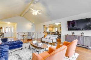 sala de estar con sofá azul y sillas de color naranja en Fort Wayne Vacation Rental about 9 Mi to Downtown!, en Ellison
