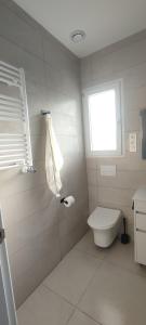 a white bathroom with a toilet and a window at Eco Home Alpera 1 in Alpera
