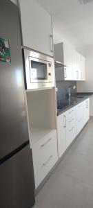 cocina con armarios blancos y microondas en Eco Home Alpera 1, en Alpera