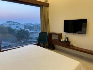 a hotel room with a bed and a large window at HOTEL ANANTA in Ambāla +38 photos