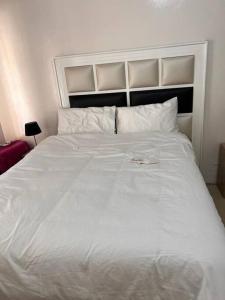 1 cama blanca grande en un dormitorio con cabecero en Four m luxury Apartment., en Kitwe