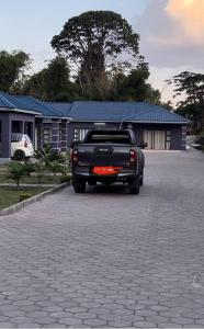a black pick up truck parked in a driveway at Four m luxury Apartment. in Kitwe