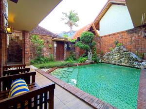 a swimming pool in a yard with a building at S Bali Villa in Nusa Dua